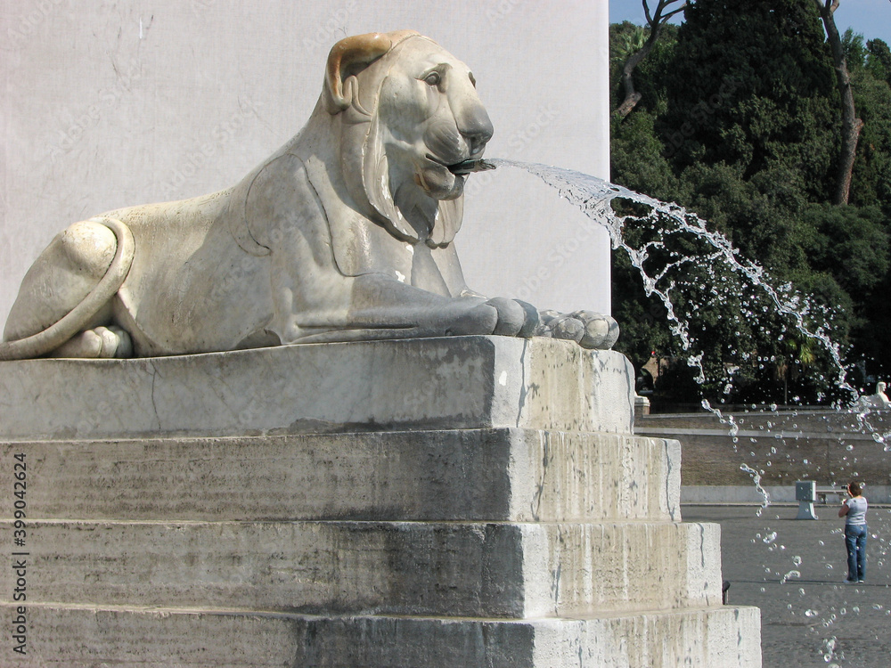 Rome, Italy - A statue of a lion spitting water Fontana dell'Obelisco in Piazza del Popolo, which translates to The People's Square in English.  Image has copy space.