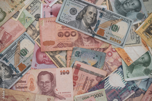 Currency exchange and forex investment concept, Closeup variety banknote around the world such as dollar Yuan Baht Won and Piso.