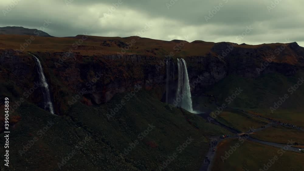 zoom in on the Seljalandsfoss waterfall in Iceland, with people sightseeing in 4k zoom in on the Seljalandsfoss waterfall in Iceland, with people sightseeing in 4k