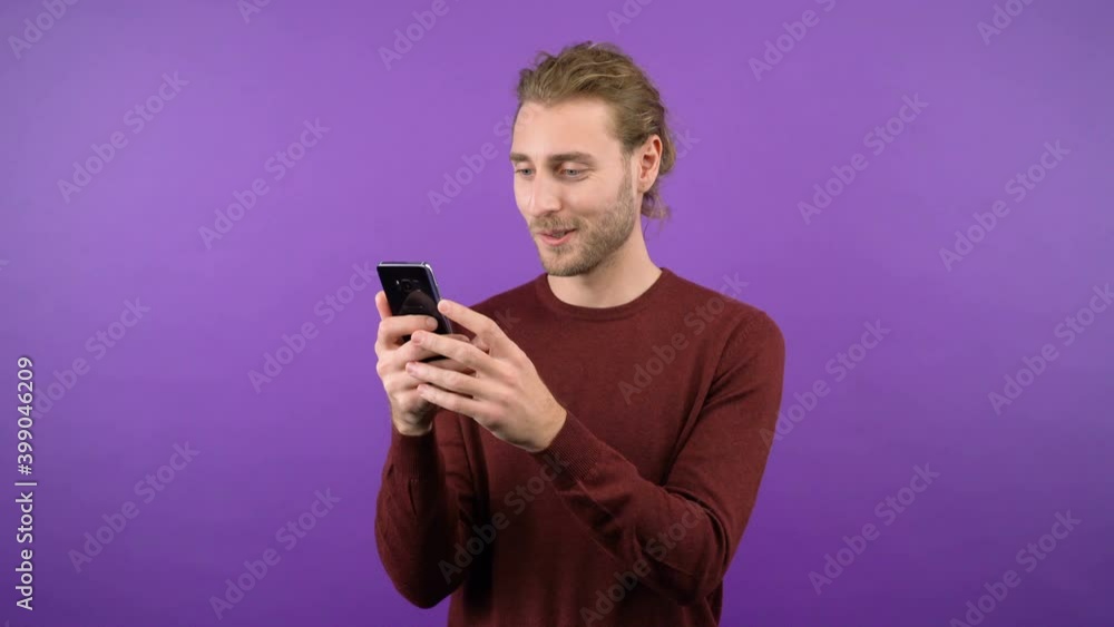 happy young pleasantly surprised scrolls through social networks and looks at the smartphone screen. 4K happy young pleasantly surprised scrolls through social networks and looks at the smartphone screen. 4K
