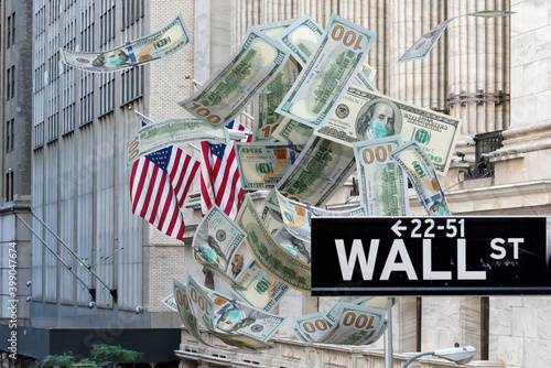  Wall Street sign and dollars bills falling cash with medical face mask against coronavirus infection Covid-19 and New York Stock Exchange on background. Aid package to fight COVID-19 gains momentum.