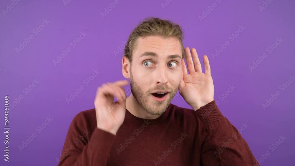 portrait of a young mysterious long-haired guy who eavesdrops on the news holding his palm near his ear 4K portrait of a young mysterious long-haired guy who eavesdrops on the news holding his palm near his ear 4K