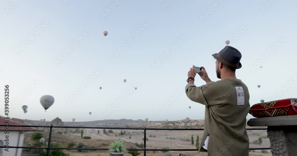 Young tourist man watching a hot air balloon tour in Cappadocia. Young tourist man watching a hot air balloon tour in Cappadocia.