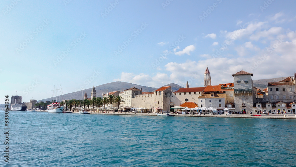 Promenade of Trogir town with stone walls and bell tower
