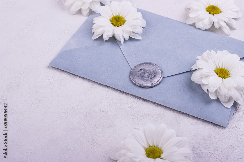 Obraz premium Blue handmade paper envelope with love wax seal, white flowers on the background