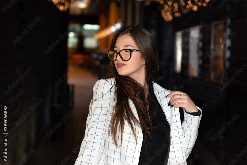 Portrait of young woman in..formal clothing in street in the evening