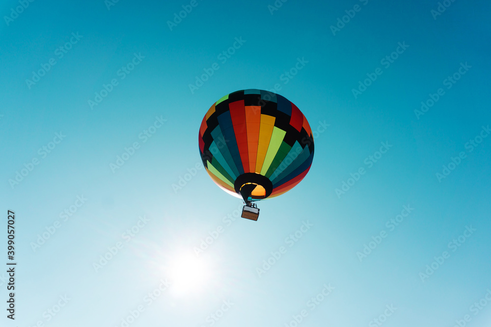 Naklejka premium Flying in a multi-colored hot air balloon. Bottom up view. Copy space