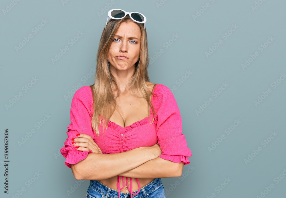 Beautiful caucasian woman wearing sunglasses and summer style skeptic and nervous, disapproving expression on face with crossed arms. negative person. Beautiful caucasian woman wearing sunglasses and summer style skeptic and nervous, disapproving expression on face with crossed arms. negative person.
