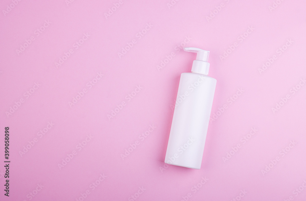 Body care product in a white bottle on a pink pastel background Body care product in a white bottle on a pink pastel background