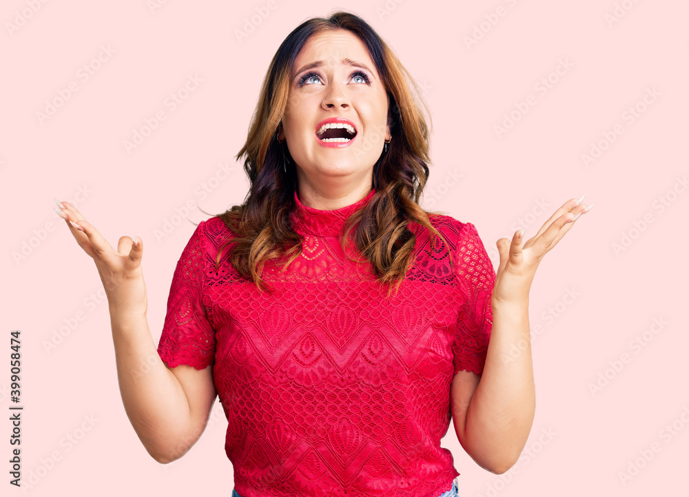 Young beautiful caucasian woman wearing casual clothes crazy and mad shouting and yelling with aggressive expression and arms raised. frustration concept. Young beautiful caucasian woman wearing casual clothes crazy and mad shouting and yelling with aggressive expression and arms raised. frustration concept.