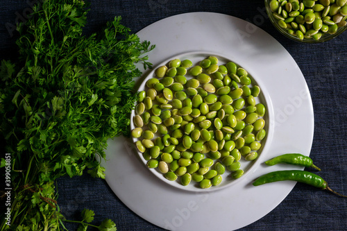 Fresh green lima beans stacked together on a white plate