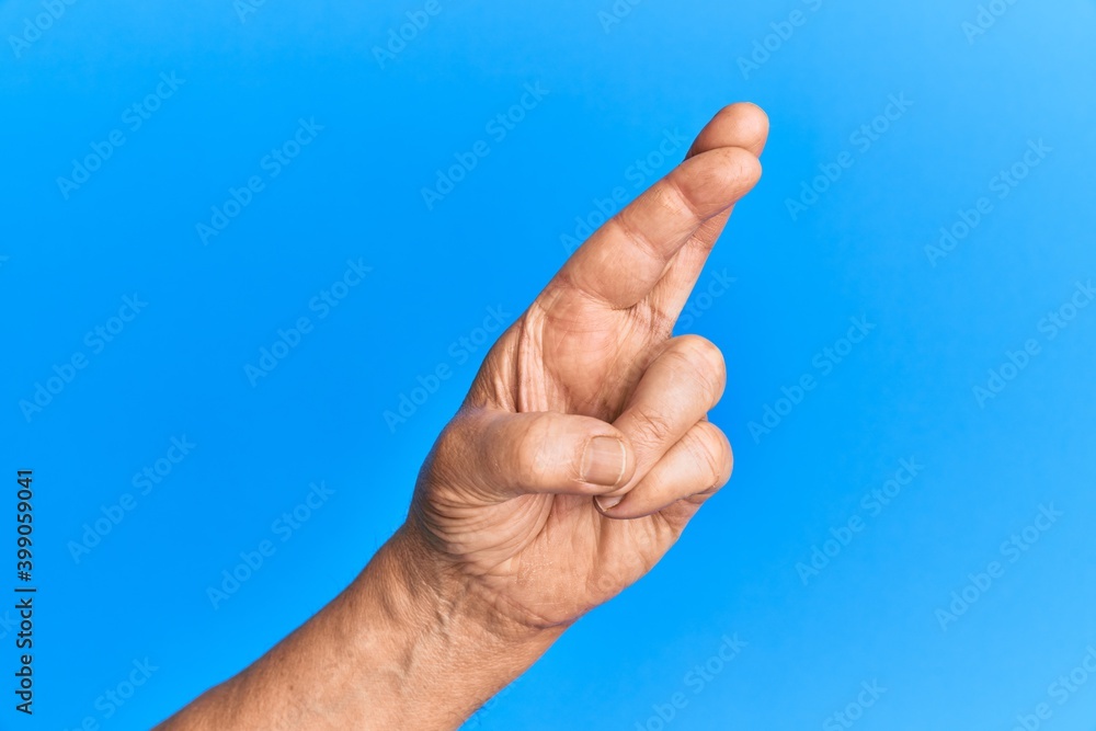 Hand of senior hispanic man over blue isolated background gesturing fingers crossed, superstition and lucky gesture, lucky and hope expression Hand of senior hispanic man over blue isolated background gesturing fingers crossed, superstition and lucky gesture, lucky and hope expression