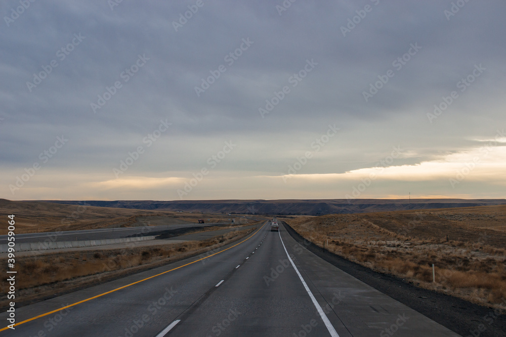 Highway in the middle of the mountains in a snowy winter. A beautiful asphalt road among the snow-covered mountains. Utah, USA
