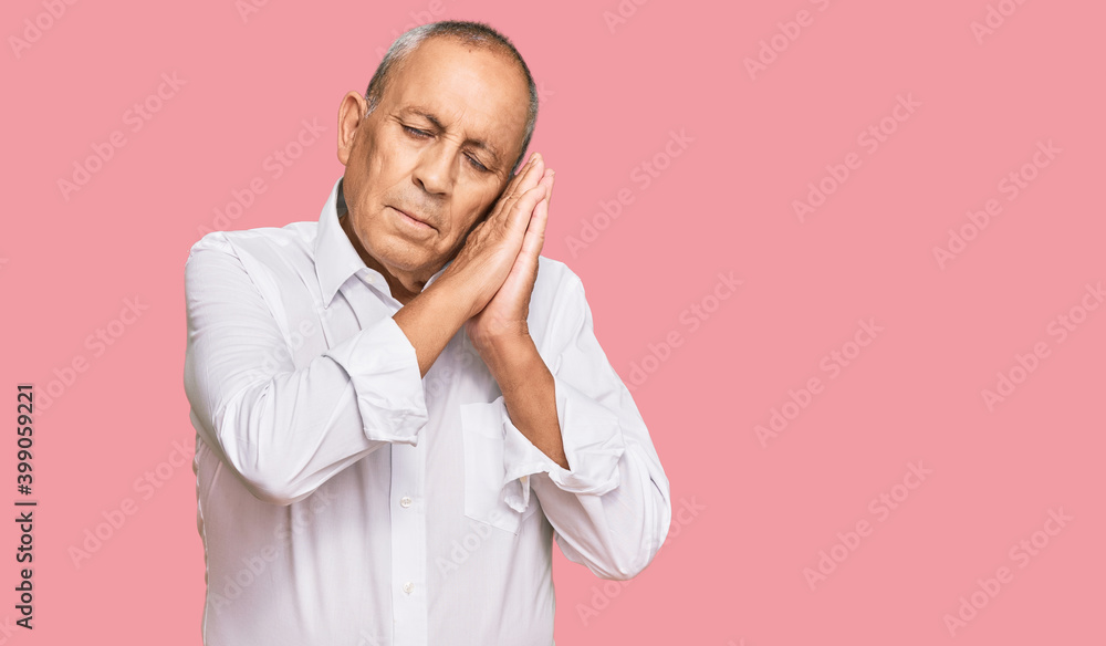 Handsome senior man wearing elegant white shirt sleeping tired dreaming and posing with hands together while smiling with closed eyes. Handsome senior man wearing elegant white shirt sleeping tired dreaming and posing with hands together while smiling with closed eyes.