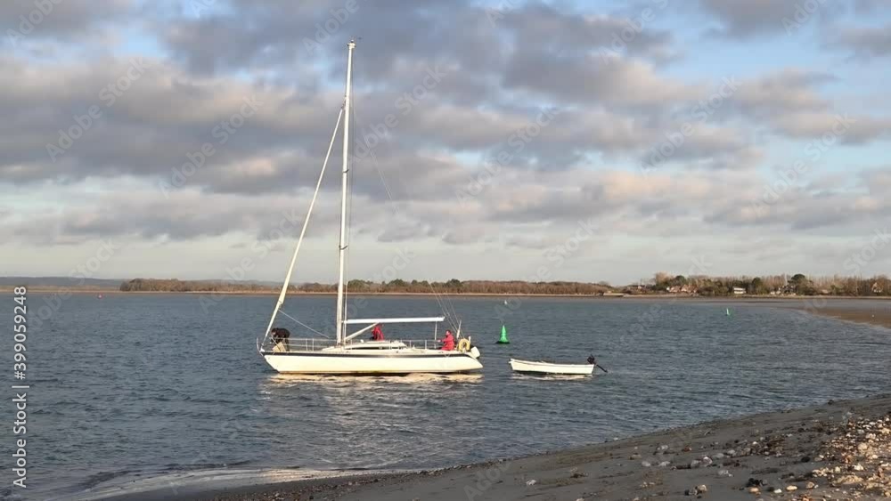 Sailing Boat heading out from East Head near West Wittering in West Sussex with no sail but under power. Sailing Boat heading out from East Head near West Wittering in West Sussex with no sail but under power.