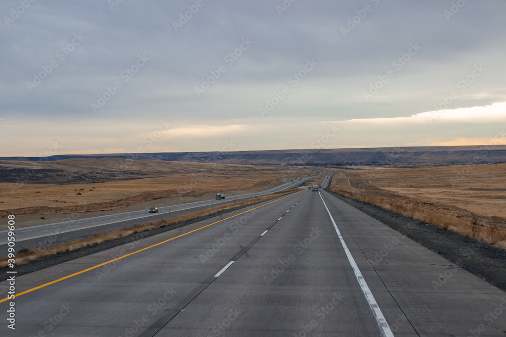 Highway in the middle of the mountains in a snowy winter. A beautiful asphalt road among the snow-covered mountains. Utah, USA
