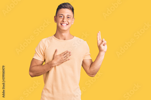 Young handsome man wearing casual clothes smiling swearing with hand on chest and fingers up, making a loyalty promise oath