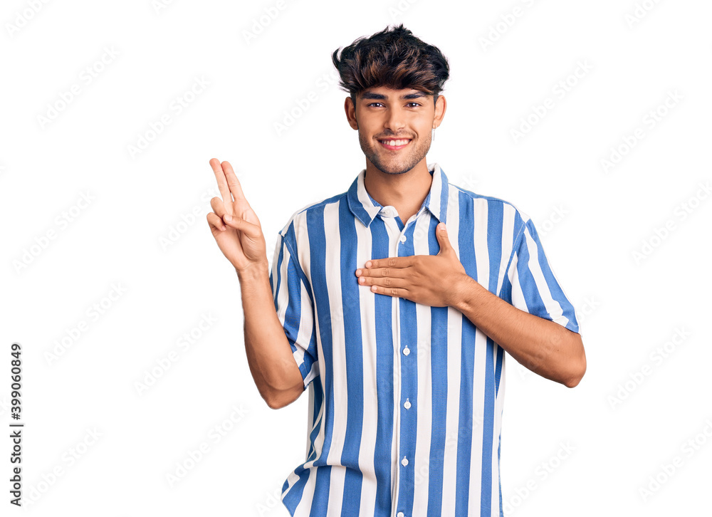Young hispanic man wearing casual clothes smiling swearing with hand on chest and fingers up, making a loyalty promise oath Young hispanic man wearing casual clothes smiling swearing with hand on chest and fingers up, making a loyalty promise oath