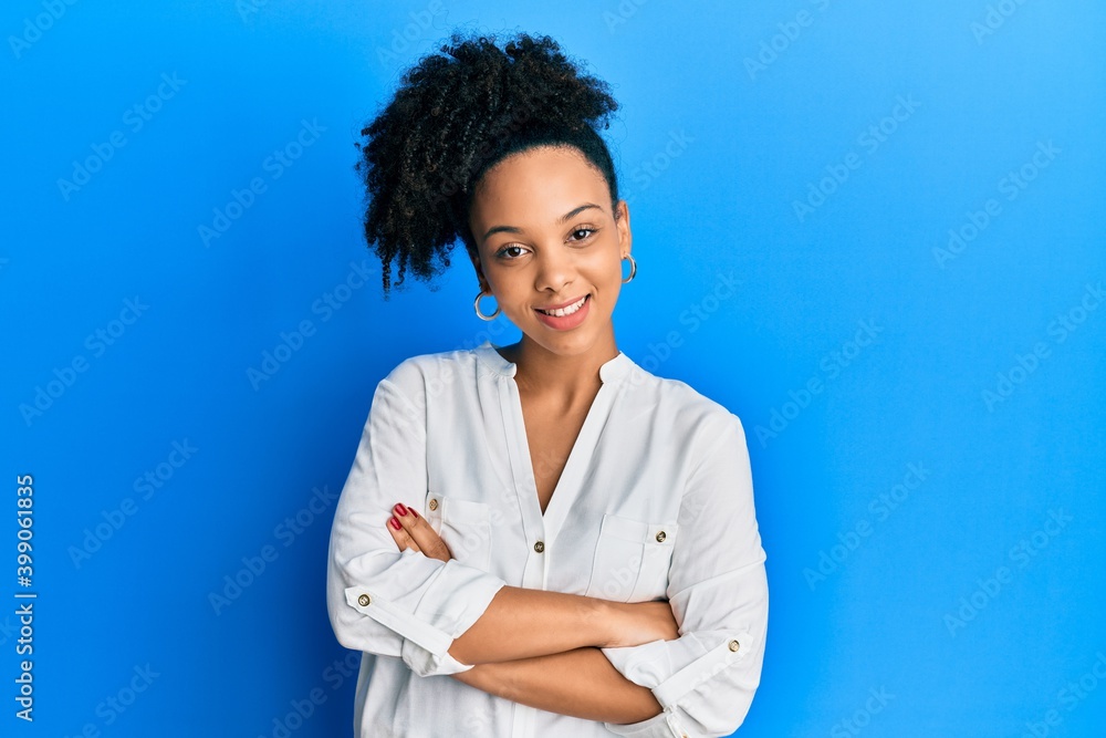 Young african american girl wearing casual clothes happy face smiling with crossed arms looking at the camera. positive person. Young african american girl wearing casual clothes happy face smiling with crossed arms looking at the camera. positive person.
