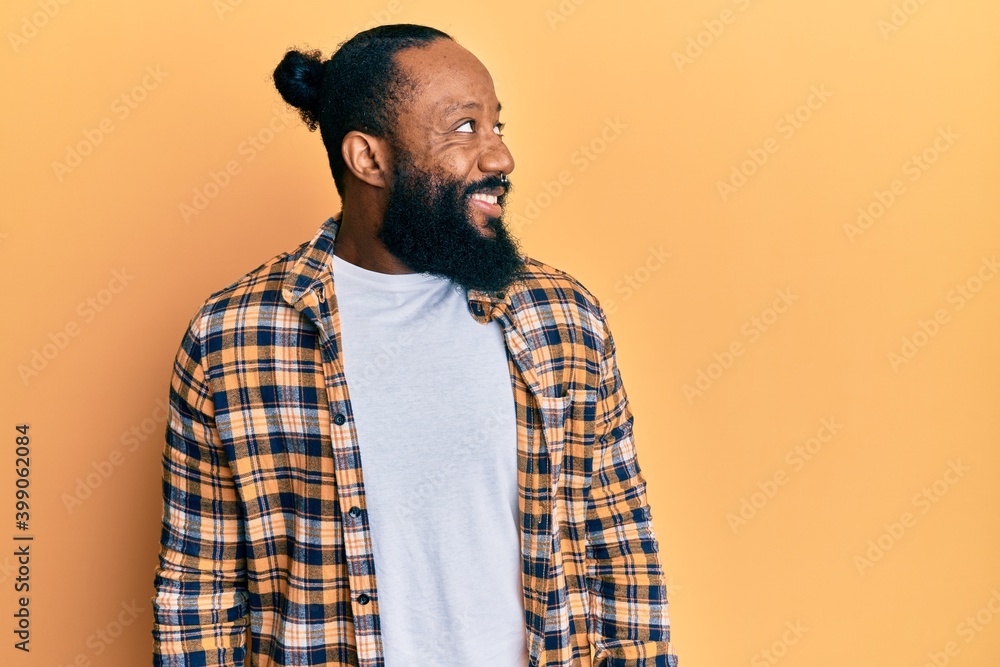 Young african american man wearing casual clothes looking to side, relax profile pose with natural face and confident smile. Young african american man wearing casual clothes looking to side, relax profile pose with natural face and confident smile.