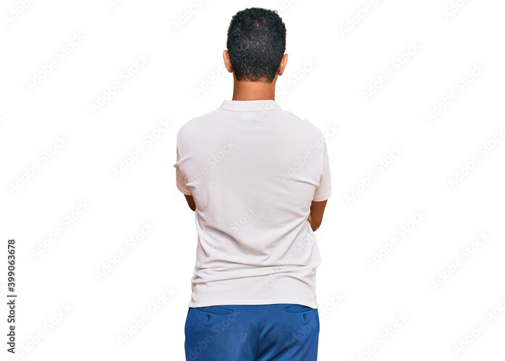 Young arab man wearing casual clothes standing backwards looking away with crossed arms Young arab man wearing casual clothes standing backwards looking away with crossed arms