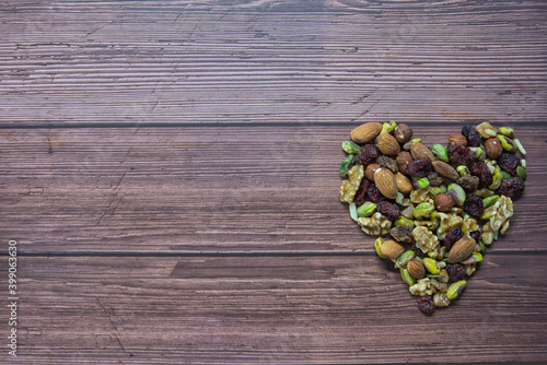 Mixed nuts, heart healthy food on a wooden background. Top view with copy space.