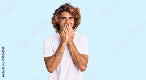 Foto Young hispanic man wearing casual white tshirt laughing and embarrassed giggle c