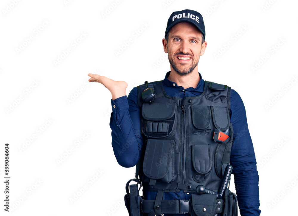 Young handsome man wearing police uniform smiling cheerful presenting and pointing with palm of hand looking at the camera. Young handsome man wearing police uniform smiling cheerful presenting and pointing with palm of hand looking at the camera.