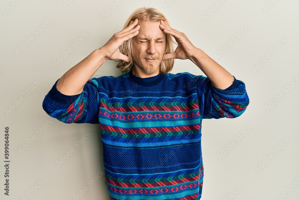 Caucasian young man with long hair wearing colorful winter sweater with hand on head, headache because stress. suffering migraine. Caucasian young man with long hair wearing colorful winter sweater with hand on head, headache because stress. suffering migraine.