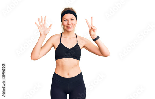 Young beautiful blonde woman wearing sportswear showing and pointing up with fingers number seven while smiling confident and happy. © Krakenimages.com