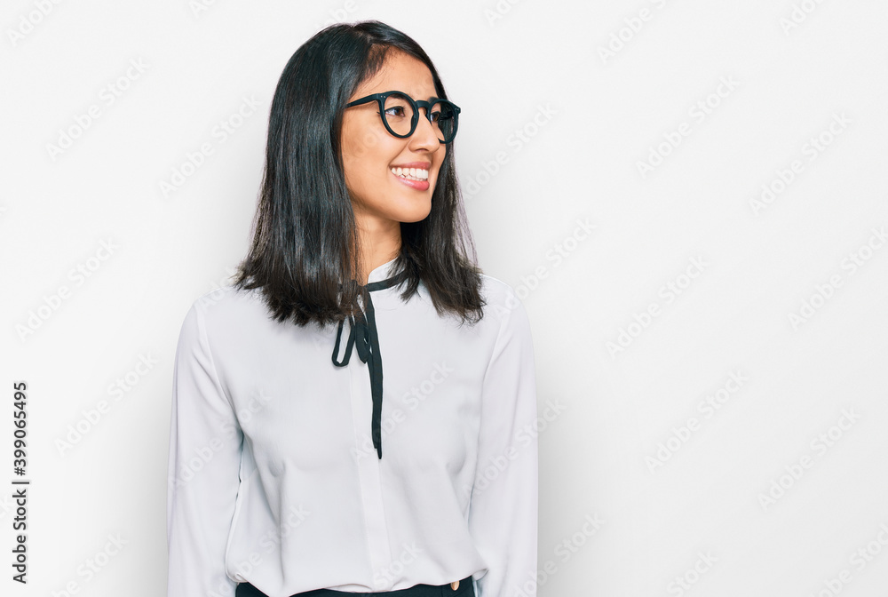 Beautiful asian young woman wearing business shirt and glasses looking away to side with smile on face, natural expression. laughing confident. Beautiful asian young woman wearing business shirt and glasses looking away to side with smile on face, natural expression. laughing confident.
