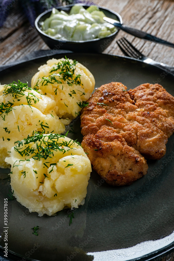 Pork chop served with mashed potatoes and cucumber salad. Pork chop served with mashed potatoes and cucumber salad.