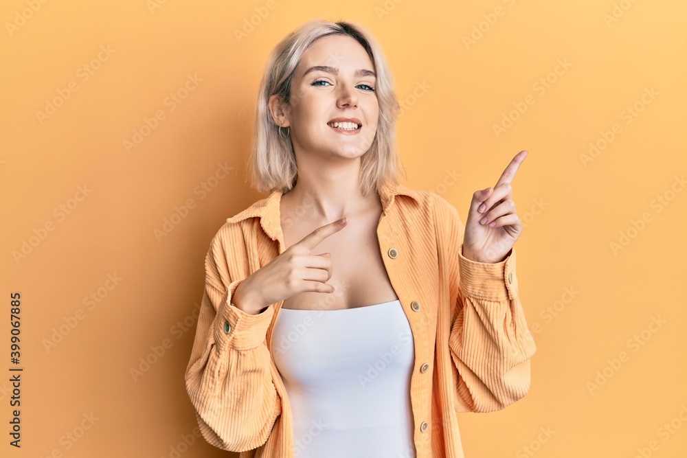 Young blonde girl wearing casual clothes smiling and looking at the camera pointing with two hands and fingers to the side. Young blonde girl wearing casual clothes smiling and looking at the camera pointing with two hands and fingers to the side.