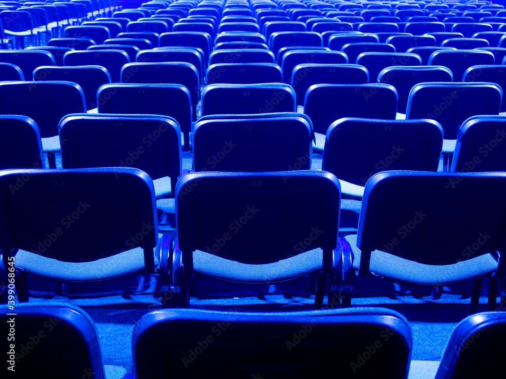 Blue chairs are placed on a row in an auditorium Blue chairs are placed on a row in an auditorium