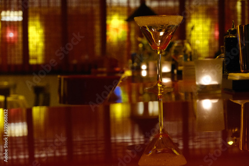 close up one drinking glass on dark bar counter. blur background