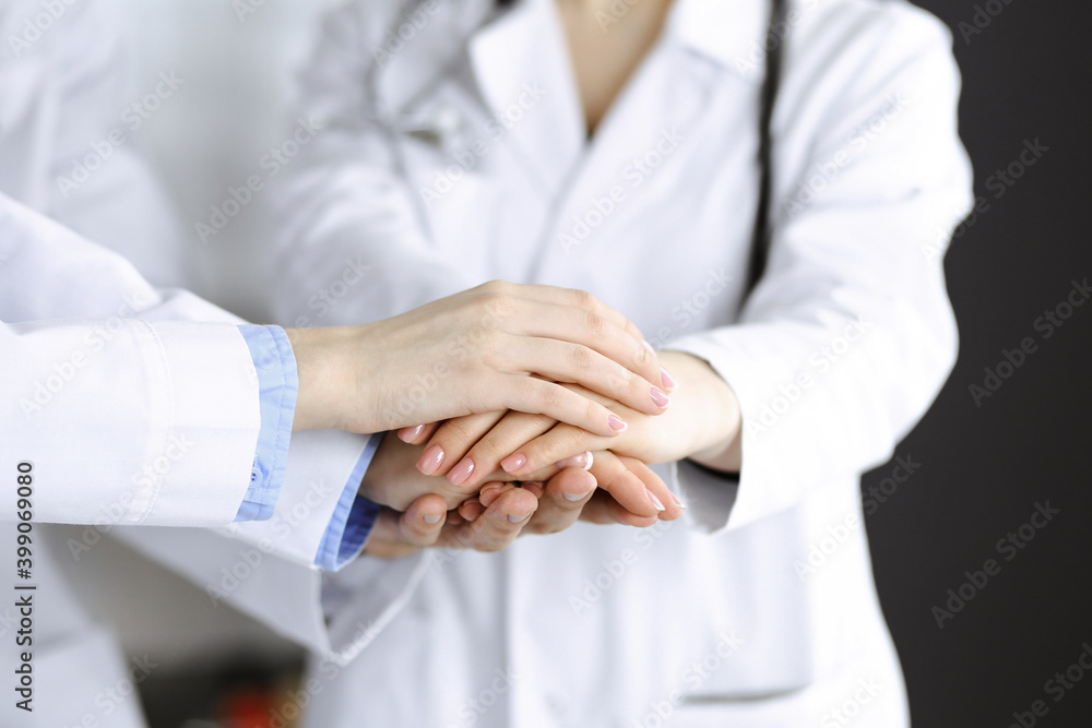 Group of modern doctors joining hands as a circle and ready to help patients. Teamwork in medicine during Coronavirus pandemic. Covid 2019 Group of modern doctors joining hands as a circle and ready to help patients. Teamwork in medicine during Coronavirus pandemic. Covid 2019