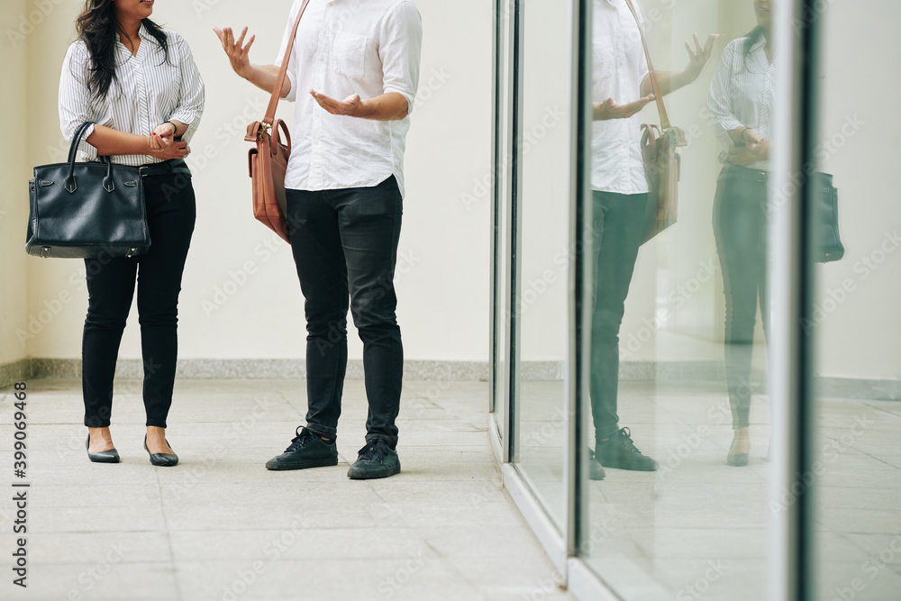 Cropped image of young business people standing outside office building and talking about important issues