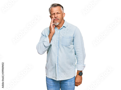 Middle age grey-haired man wearing casual clothes touching mouth with hand with painful expression because of toothache or dental illness on teeth. dentist