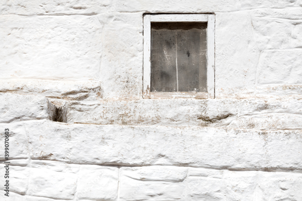 Finestrino su vecchio muro bianco