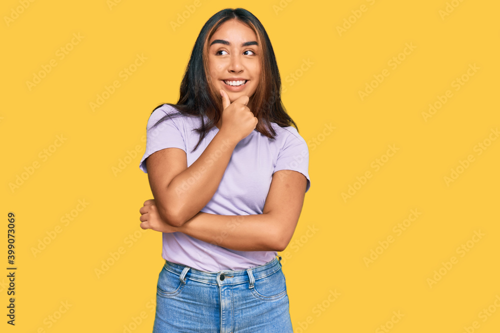 Young latin woman wearing casual clothes with hand on chin thinking about question, pensive expression. smiling with thoughtful face. doubt concept. Young latin woman wearing casual clothes with hand on chin thinking about question, pensive expression. smiling with thoughtful face. doubt concept.