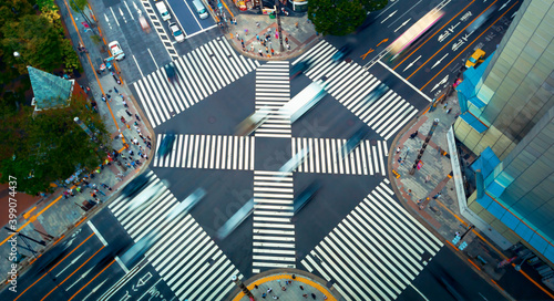 Traffic and people cross a busy intersection in Ginza, Tokyo