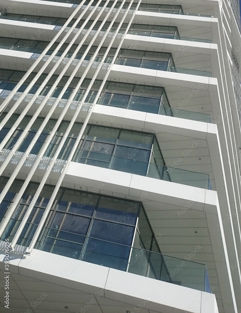 Close up of a modern office building with balconies and vertical sun shades. Close up of a modern office building with balconies and vertical sun shades.