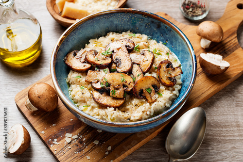 Risotto with brown champignon mushrooms on wooden background. 