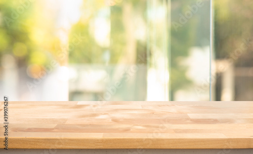 Empty wood table top on blur abstract window glass view.