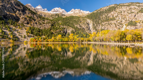 Water reflection of yellow autumn woods with Snow cap mountain peak of Ordesa National park
