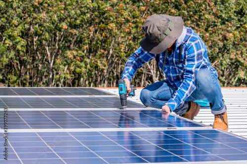 man installing solar panels on a home rooftop for alternative energy photovoltaic safe energy. power from nature sun power solar cell generator.