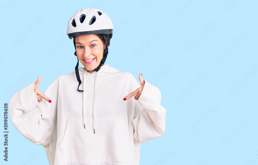 Beautiful brunette young woman wearing bike helmet and sporty clothes looking confident with smile on face, pointing oneself with fingers proud and happy. Beautiful brunette young woman wearing bike helmet and sporty clothes looking confident with smile on face, pointing oneself with fingers proud and happy.