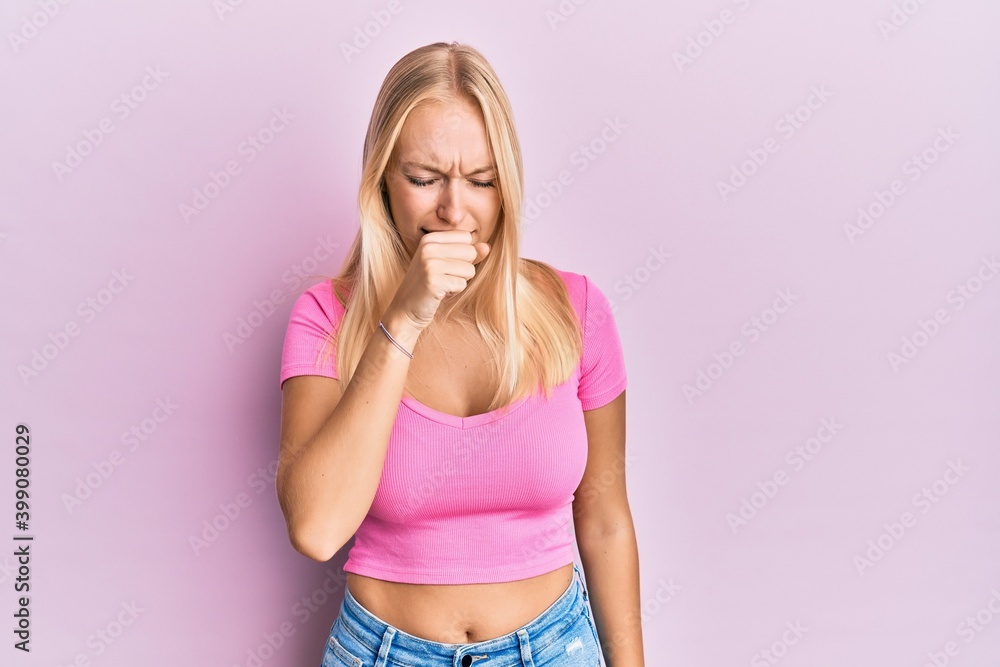 Young blonde girl wearing casual clothes feeling unwell and coughing as symptom for cold or bronchitis. health care concept. Young blonde girl wearing casual clothes feeling unwell and coughing as symptom for cold or bronchitis. health care concept.
