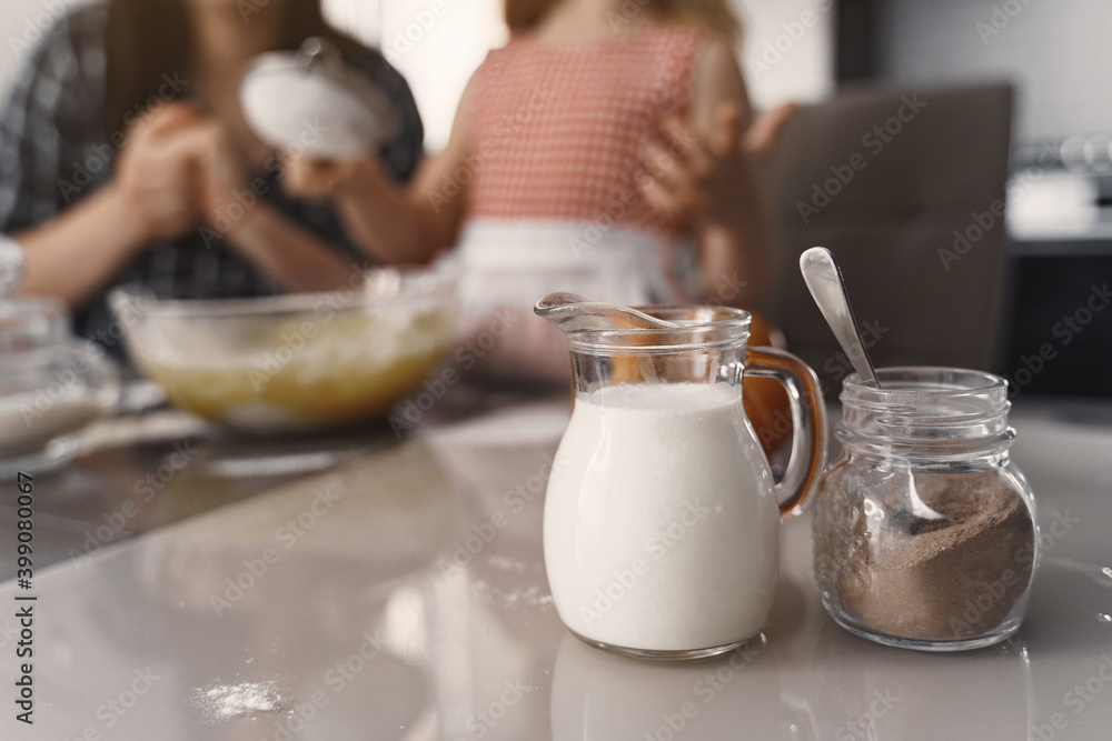 Family in a kitchen. Beautiful mother with little daughter. Woman in a black shirt. Family in a kitchen. Beautiful mother with little daughter. Woman in a black shirt.