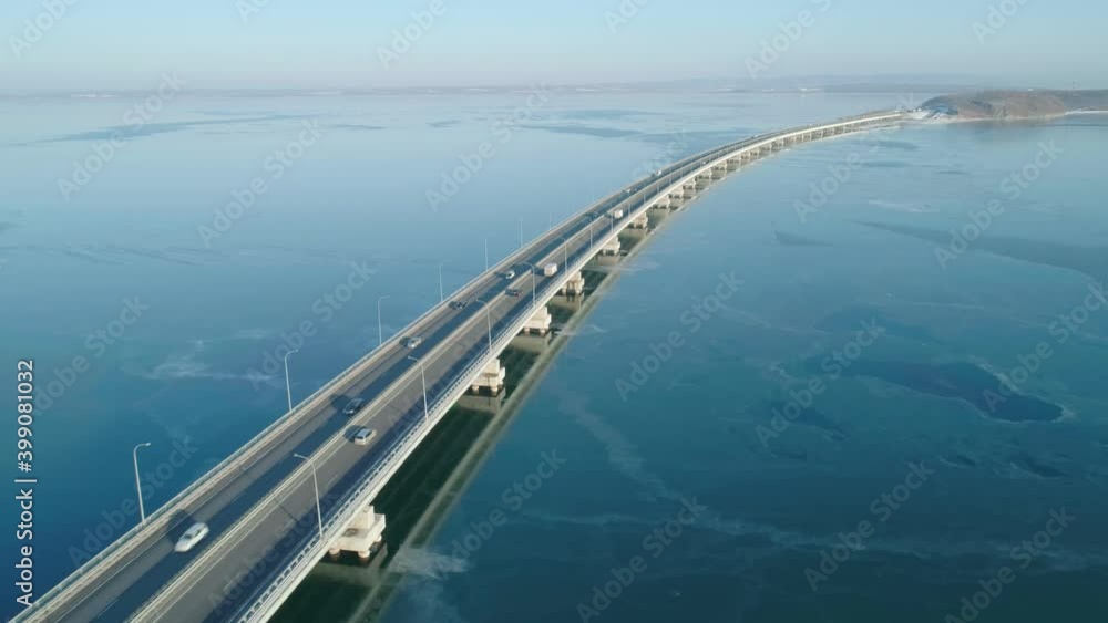 Aerial drone view of low-water bridge across the bay with moving car. Active movement of transport cars vehicles in different directions. Aerial drone view of low-water bridge across the bay with moving car. Active movement of transport cars vehicles in different directions.